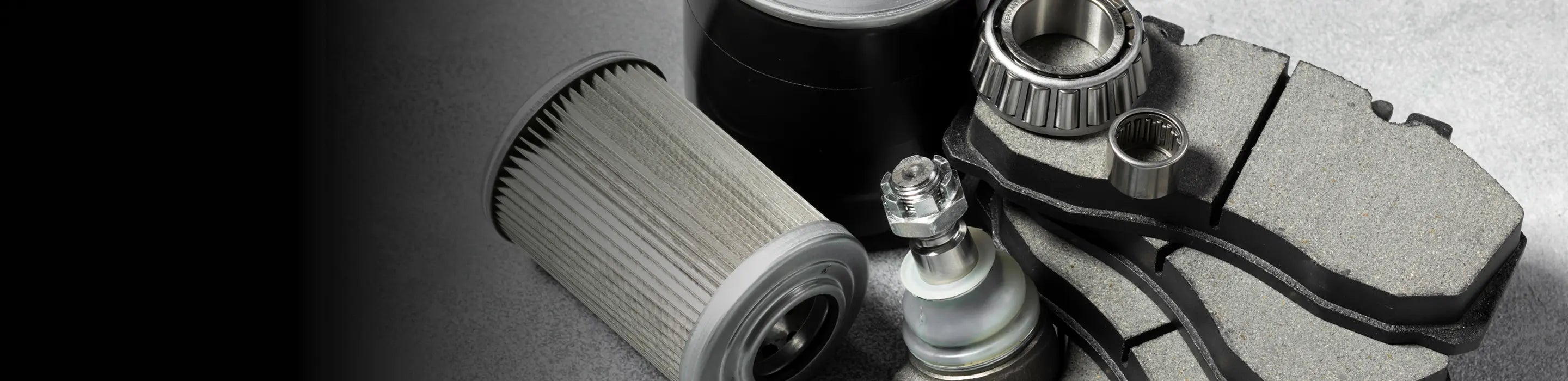 Assortment of automotive filters, bearings, and brake parts on a clean background