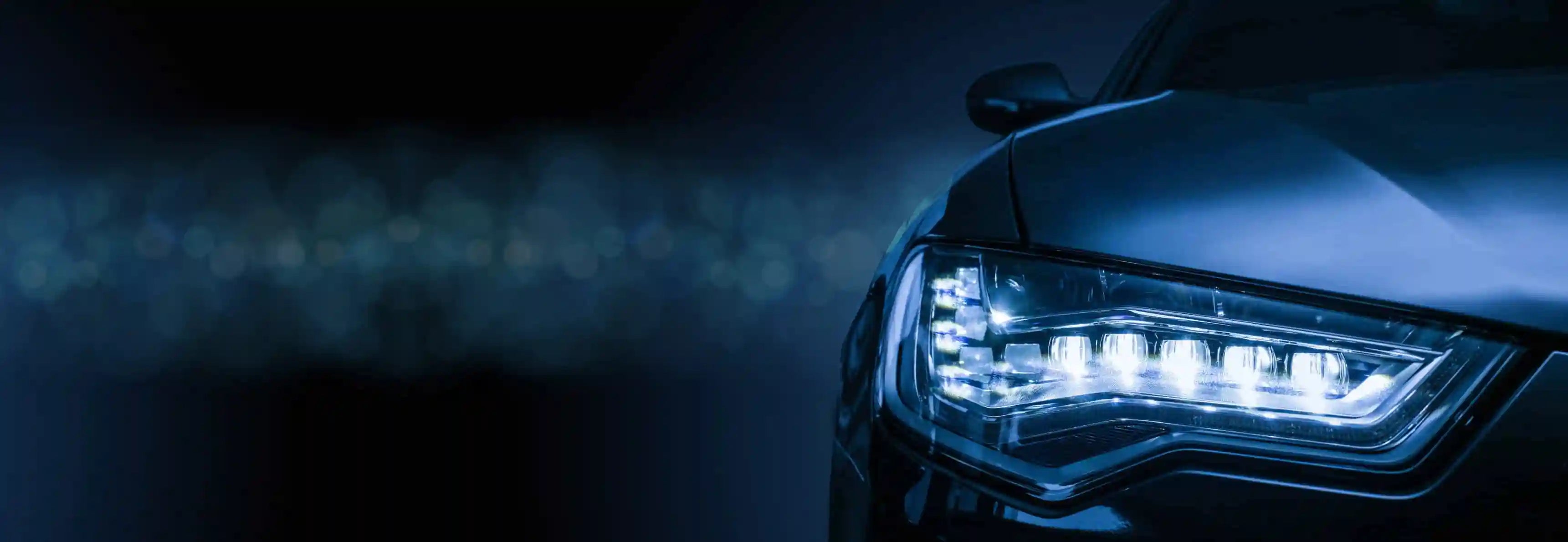 Premium auto parts banner showing a close-up of a car headlight – PartsPrime